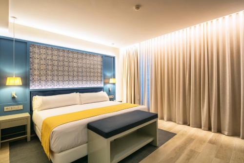 a bedroom with a bed and a window with curtains at Catalonia Porto in Porto