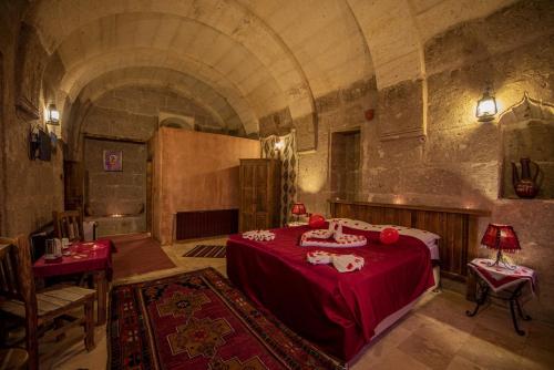 a large room with a red bed in a building at Kapadokya Ihlara Konakları Otel Konak Odaları in Guzelyurt