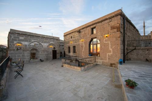a large brick building with a patio in the middle at Kapadokya Ihlara Konakları Otel Konak Odaları in Guzelyurt