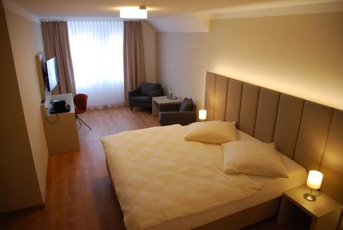 1 dormitorio con 1 cama grande y sala de estar en Walldorf Suites Boutique Hotel, en Walldorf