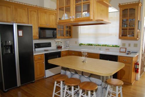 a kitchen with a black refrigerator and a table with stools at 5th Street Inn in Mariposa