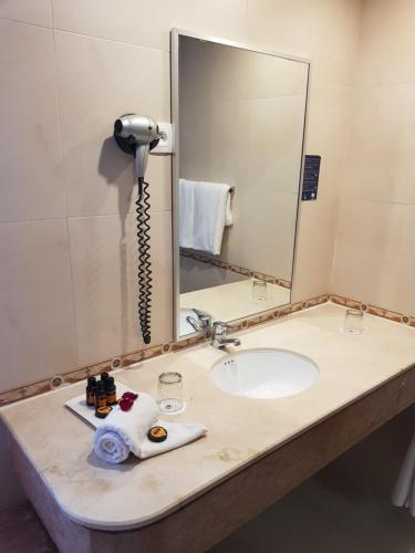a bathroom counter with a sink and a phone at El Oumnia Puerto & Spa in Tangier
