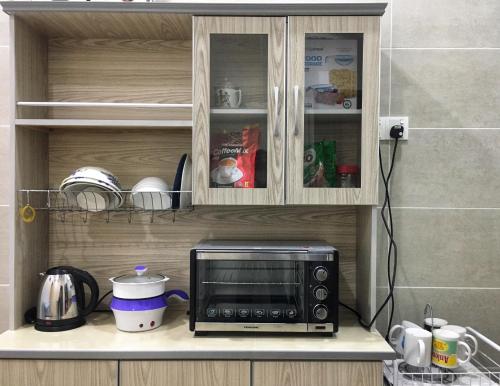 a microwave sitting on a counter in a kitchen at Batu Pahat Leisure Stay in Batu Pahat