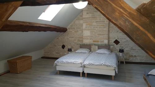 una camera da letto con letto bianco in mansarda di Gîte La P'tite Louise a Les Riceys