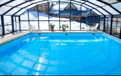 une grande piscine avec un toit en verre dans l'établissement vg5 Location Montagne à Saint François LONGCHAMPS, à Saint-François-Longchamp