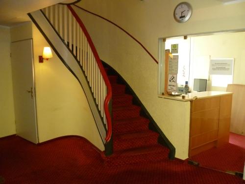 eine Treppe in einem Gebäude mit einer Uhr an der Wand in der Unterkunft Domo Hotel Mondial in Düsseldorf