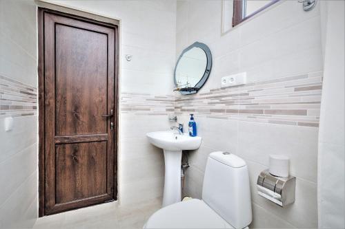 a bathroom with a toilet and a sink and a mirror at Tinikos Guest House in Tʼelavi