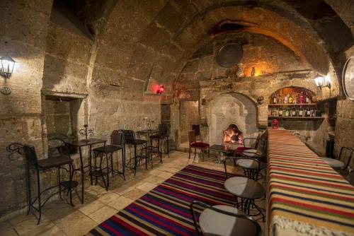 a bar with a fireplace in a stone building at Akinci Konagi Hotel in Guzelyurt