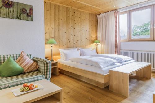 a hotel room with a bed and a couch at Schlegelhof in Kirchzarten