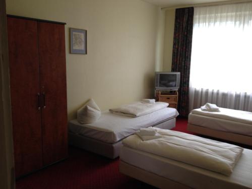 a hotel room with two beds and a television at Domo Hotel Mondial in Düsseldorf