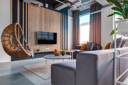 uma sala de estar com um sofá e uma televisão em Roomy Hostel em Ecaterimburgo