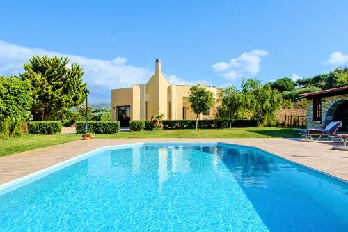 - une piscine en face d'une maison dans l'établissement Villa Evelina, à Adelianos Kampos