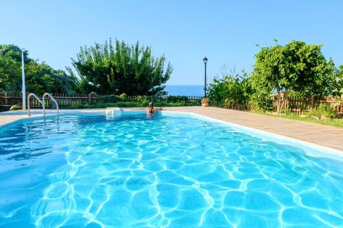- une piscine avec une personne dans l'eau dans l'établissement Villa Evelina, à Adelianos Kampos