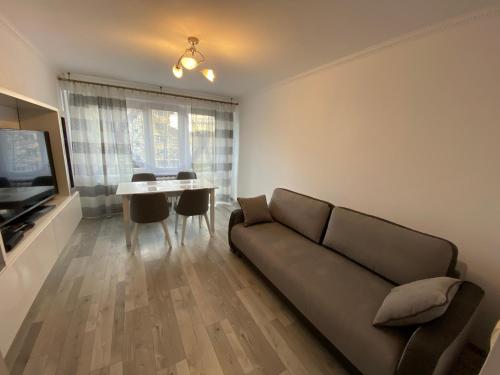 a living room with a couch and a table at Apartament Zacisze in Ustrzyki Dolne
