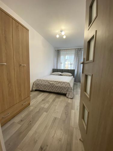 a bedroom with a bed and a wooden floor at Apartament Zacisze in Ustrzyki Dolne