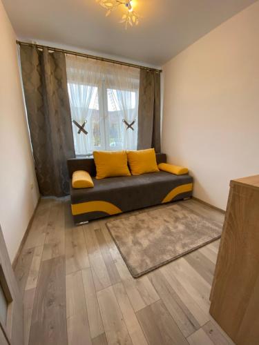 a living room with a couch and a window at Apartament Zacisze in Ustrzyki Dolne