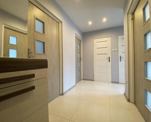 a hallway of a home with a door and tile floor at Apartament Zacisze in Ustrzyki Dolne