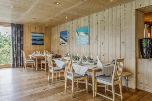 a dining room with wooden walls and tables and chairs at Schlegelhof in Kirchzarten