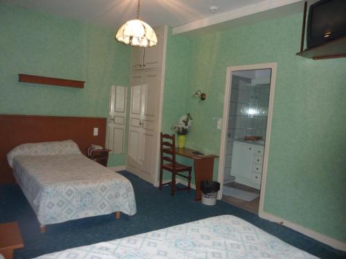 ル・ビュグにあるHotel de Parisのベッドルーム1室(ベッド2台、デスク、鏡付)