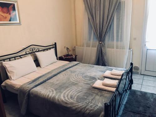 a bedroom with a large bed with towels on it at Guesthouse Adonis in Kato Loutraki