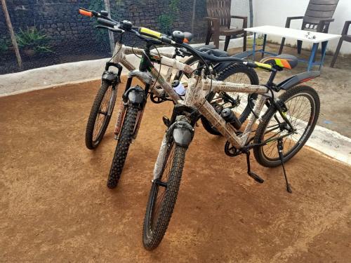 Twee fietsen stonden naast elkaar geparkeerd in de modder. bij Namaste Homestay in Khajurāho