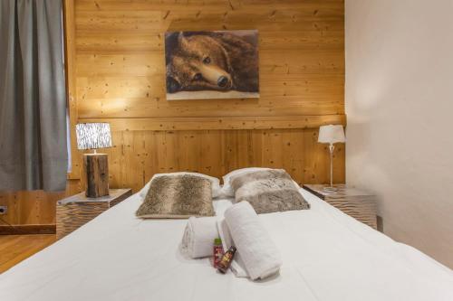 1 dormitorio con 1 cama con una foto de un oso en Luxurious flat w sauna in L'Alpe d'Huez - Welkeys, en LʼHuez