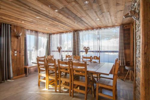 comedor con mesa de madera y sillas en Luxurious flat w sauna in L'Alpe d'Huez - Welkeys, en LʼHuez
