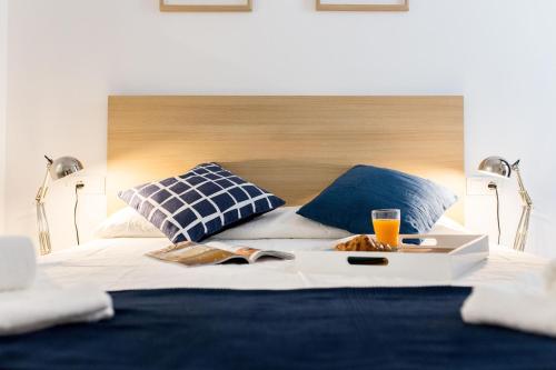a bed with two pillows and a tray of food on it at Oceanográfico Apartments in Valencia