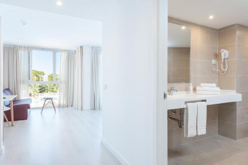 a bathroom with a sink and a mirror at Aparthotel Ses Fotges in Playa de Muro