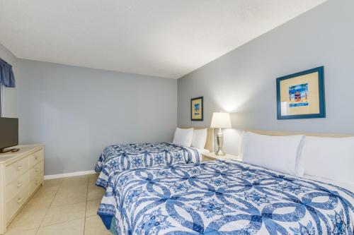 a bedroom with two beds and a tv at Hosteeva Ocean Forest Plaza w Beachview Balcony in Myrtle Beach