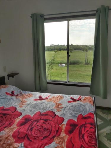 a bedroom with a bed with red roses on it at Cabañas San Jorge in Termas del Daymán