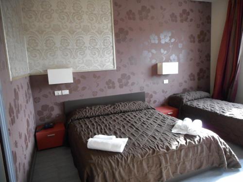 a hotel room with two beds with towels on them at Residence San Marino in San Marino