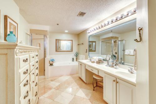 a bathroom with a tub and a sink and a tub at Enclave 1004 in Orange Beach