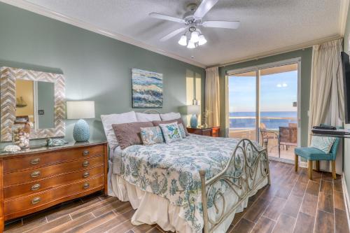 ein Schlafzimmer mit einem Bett mit einer Kommode und einem Spiegel in der Unterkunft Enclave 1004 in Orange Beach