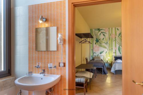 a bathroom with a sink and a dining room at Villa Rosaria Rooms in Noto