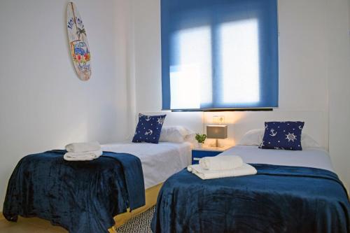 ベルレガートにあるMigjorn Mar de Bellreguard AP9のベッド2台(青いシーツ付)、窓が備わる客室です。