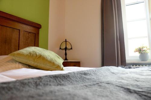 a bedroom with a bed with a pillow and a window at Ferienweingut Niessner in Ernst