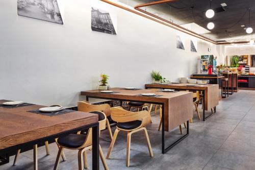 a dining room with wooden tables and chairs at One Shot Tabakalera House in Donostia-San Sebastián