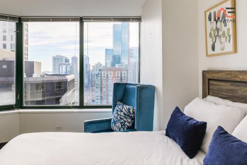 a bedroom with a bed and a blue chair at ENVITAE 3BR Spacious Lux Skyview Of Navy Pier in Chicago