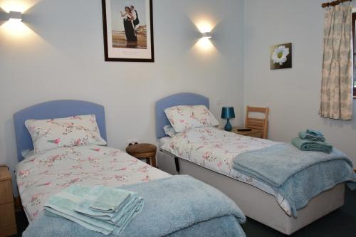 Finest Retreats - Shropshire Cottage, 2 bedrooms, sleeps 3 في Marchamley: غرفة نوم بسريرين عليها مناشف