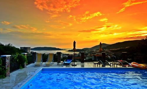 une piscine avec vue sur le coucher du soleil en arrière-plan dans l'établissement Apartments Villa Čučuk, à Budva