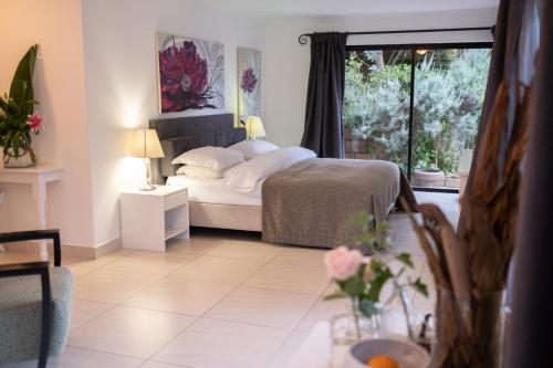 a bedroom with a bed and a window at Dreamhouse Guest House in Hout Bay