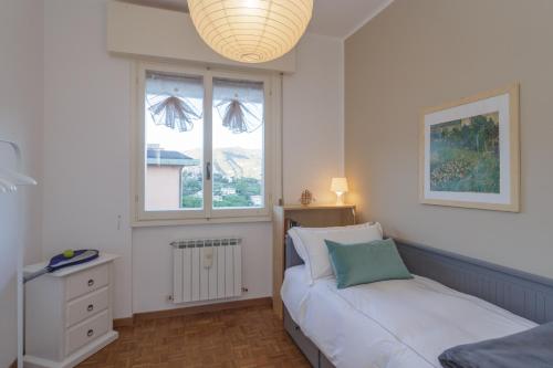 a small bedroom with a bed and a window at Casa Linda - Incredible View, Pool & Tennis in Rapallo