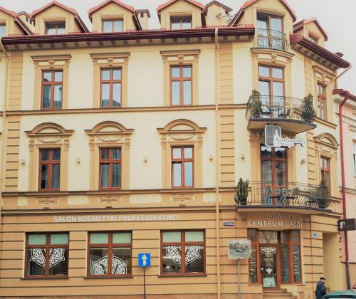 a large yellow building with windows on a street at Apartamenty Przemyśl in Przemyśl