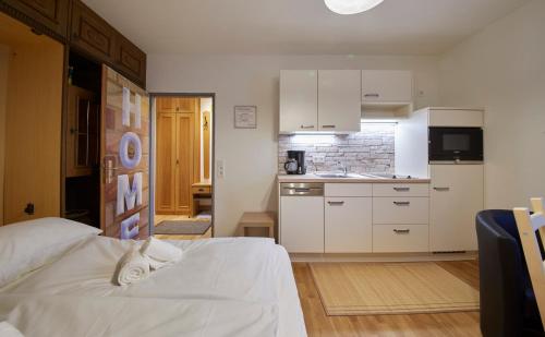 sypialnia z białym łóżkiem i kuchnią w obiekcie Appartement Mamas Iglu w Saalbach Hinterglemm