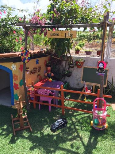 a toy house with a bed in a garden at Casa Litoral Sul - Praia Bela/ PB in Pitimbu