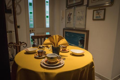 einen Tisch mit einem gelben Tischtuch mit Schalen und Tassen in der Unterkunft Spicchio di Luna in Pontinia