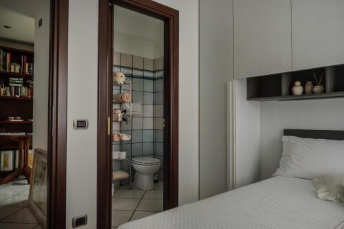 a bedroom with a bed and a bathroom with a toilet at Spicchio di Luna in Pontinia