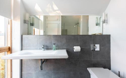 y baño con lavabo y espejo. en The Glasshouse Escape - 5BDR Jewel, en Oxford