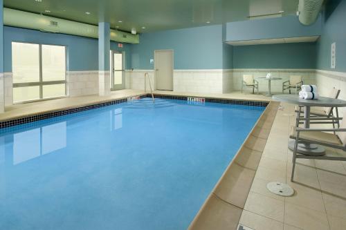 a large swimming pool with a table and chairs at Holiday Inn Express & Suites by IHG Altoona by IHG in Altoona